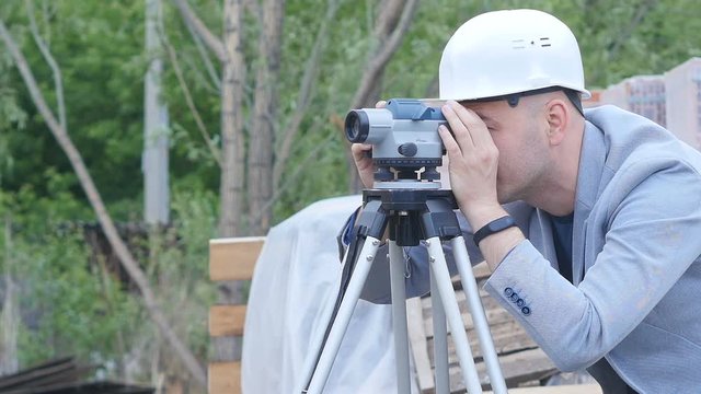 Engineer on a construction site with a laser measuring device