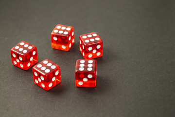 Red cubes for board games on a black background.