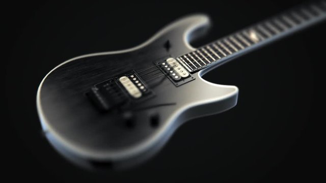 Tilt-shift effect shot of elegant, black six-string electric guitar. Music.