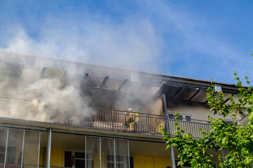 ein Feuerwehrmann versucht ein Wohnungsbrand in einem Hochhaus zu löschen