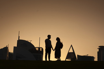 Couple silhouette in city landscape background.