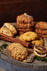 Conceptual festive composition with a cup of hot tea, cookies and spicies on a wooden barrel, selective focus, close-up
