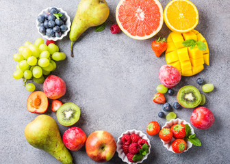 Overhead shoot with fresh assorted fruits and berries on light gray background. Colorful clean and healthy eating. Detox food. Copy space. Top view.