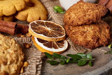 Conceptual festive composition with a cup of hot tea, cookies and spicies on a wooden barrel, selective focus, close-up