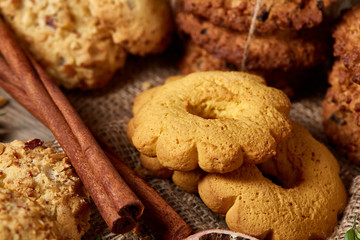 Conceptual festive composition with a cup of hot tea, cookies and spicies on a wooden barrel, selective focus, close-up