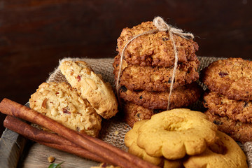Conceptual festive composition with a cup of hot tea, cookies and spicies on a wooden barrel, selective focus, close-up