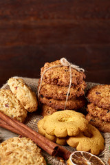 Conceptual festive composition with a cup of hot tea, cookies and spicies on a wooden barrel, selective focus, close-up