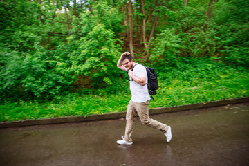 Fototapeta na wymiar young adult main running under the rain. rainy weather
