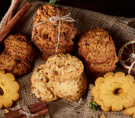 Conceptual composition with assortment of cookies and cinnamon on a wooden barrel, selective focus, close-up
