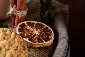 Conceptual composition with assortment of cookies and cinnamon on a wooden barrel, selective focus, close-up