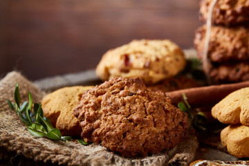 Conceptual composition with assortment of cookies and cinnamon on a wooden barrel, selective focus, close-up