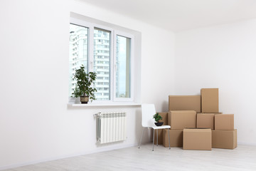 Moving into a new apartment. Move lots of cardboard boxes in an empty new apartment.