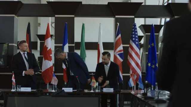 Official representatives shaking hands in agreement on international conference and posing for photo of social media