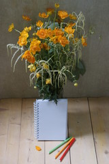 beautiful summer bouquet with yellow-orange flowers, open Notepad for records and markers
