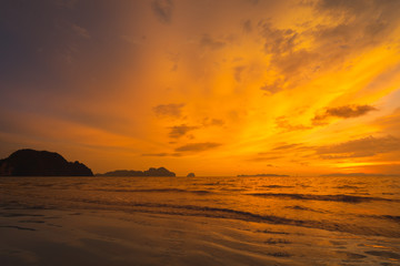 Fototapeta na wymiar Tropical sunset on the beach with stone and sand.