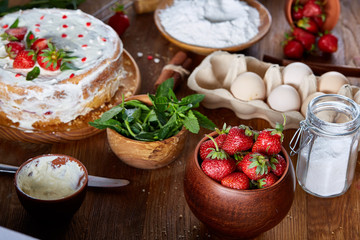 Top view raw ingredients for cooking strawberry pie or cake on wooden table, flat lay. Bakery background.