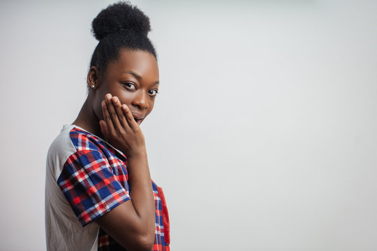 close up side view portrait of surprised African woman pocking into other people's business. pry into affairs.girl is prying how man is changing his clothes. copy space