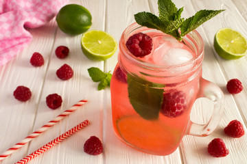 Cold lemonade with  raspberries, lime  and mint on the  white wooden  background