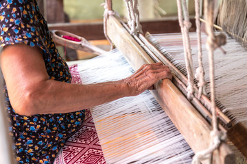 The hands of old woman weaving, the ancient weaving method.