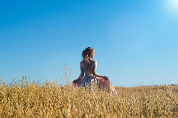 beautiful girl in beige dress in field rye 