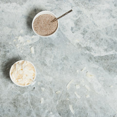 Raw Chia Seeds. Desiccated Coconut. Marble Table.