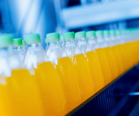 Conveyor with bottles for juice or water. Beverages factory equipments