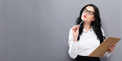 Office woman with a clipboard on a solid background