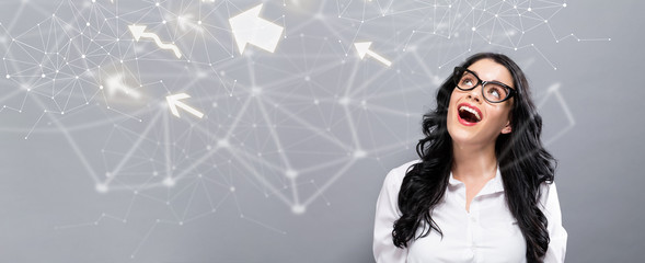 Arrows with happy young businesswoman on a gray background