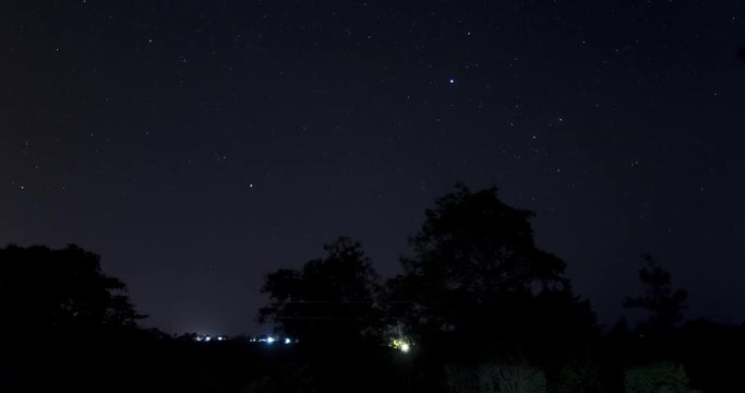 A moving time-lapse of the stars by a quiet road with power lines