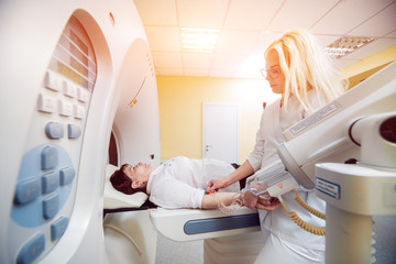 Doctor and patient in the room of computed tomography at hospital.