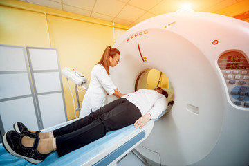Doctor and patient in the room of computed tomography at hospital.