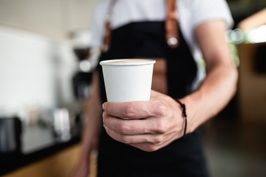 Barista Holding Cup Of Coffee To Go.