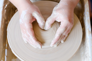 pottery workshop. handmade craft. artisan working with clay on turning potter wheel.