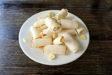 Delicious sliced pork fat with spices,  on plate on wooden background close up. Meat platter. Top view