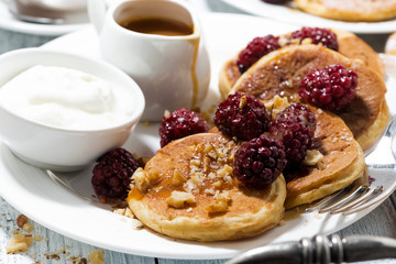 sweet corn pancakes with berries and caramel sauce for breakfast, closeup
