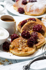 sweet corn pancakes with berries and caramel sauce, vertical closeup
