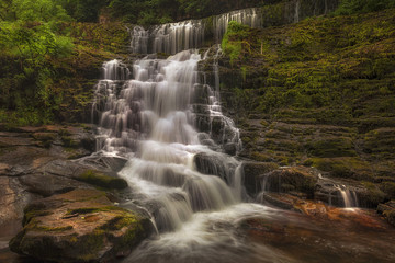Obraz premium The top section of Sgwd Clun Gwyn from the west bank, on the Mellte river, near Pontneddfechan in South Wales, UK. 