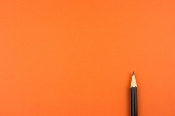 Pencil on orange tone color paper. Empty space for text and design. Minimalism concept.