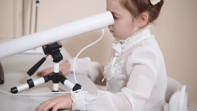 a portrait of a child who looks in an ophthalmic tube, a teenager checks vision in a children's clinic, a girl measures the level of clarity of the eyeball