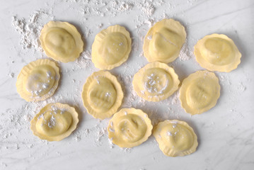 uncooked ravioli on marble