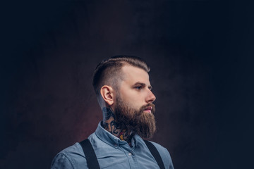 Profile of a handsome old-fashioned hipster in a blue shirt and suspenders.