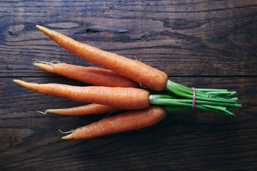Healthy organic new carrot bunch on rustic wooden table top view 