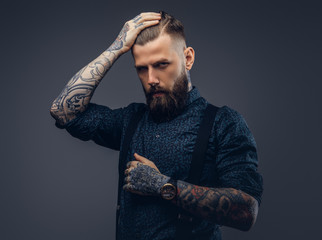 Portrait of a serious handsome old-fashioned hipster in shirt and suspenders.