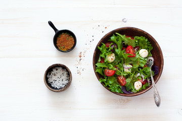 Salad with fresh lettuce, arugula, tomatoes and mozzarella