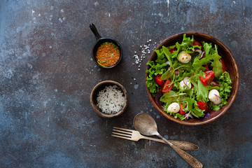 Salad with fresh lettuce, arugula, tomatoes and mozzarella