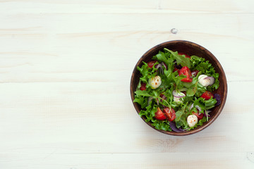 Salad with fresh lettuce, arugula, tomatoes and mozzarella