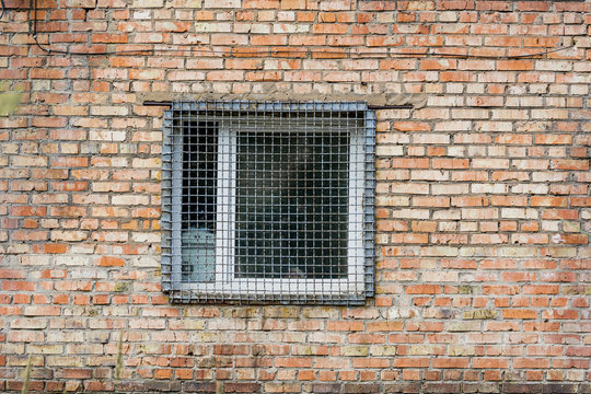 The window behind the iron grate in a brick wall. Prison