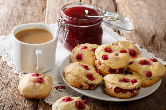 Country style scones with berries are served with English tea and jam close-up. horizontal