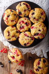 Freshly baked muffins with black and red currant berries close-up. Vertical top view from above