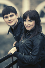 Happy young couple wearing black leather jackets in city street